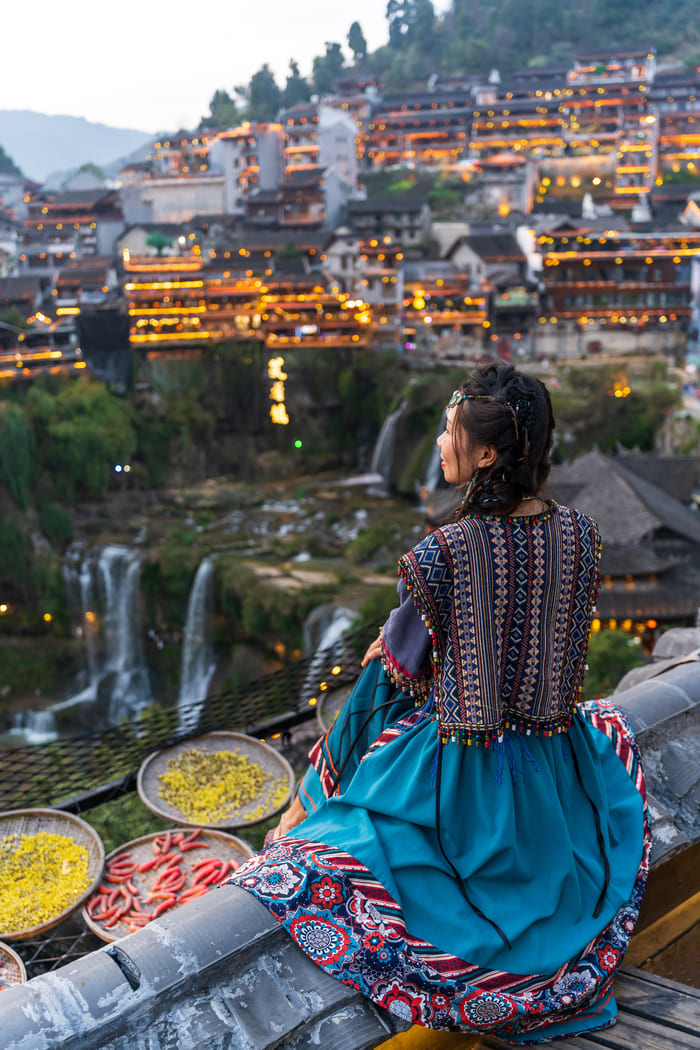 Mujer china observando las cascadas en la Ciudad vieja de Lijiang, China